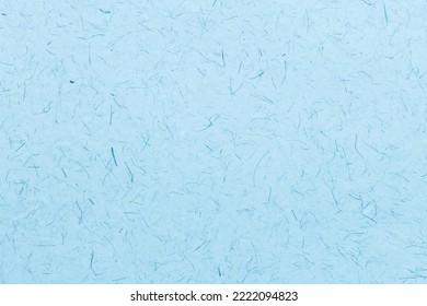 Closeup of blue tinted recycled paper with visible fibers.