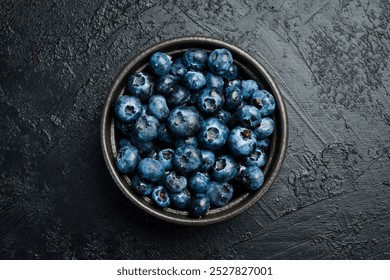 Close-up of blueberries in a bowl on a black slate table. - Powered by Shutterstock