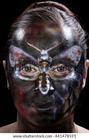 close-up body art - butterfly Totenkopf on the girl's face on a black background Studio