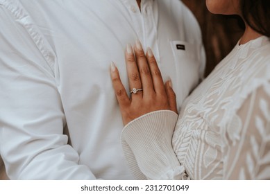 Close-up of boho couple in nature holding hands and walking, hugging having fun for their engagement photo session. - Powered by Shutterstock