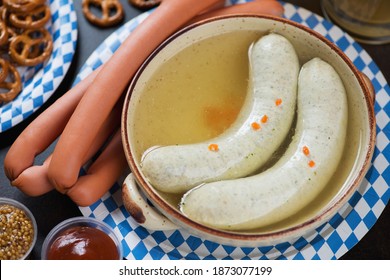 Close-up Of Boiled Munich Sausages In A Broth And Vienna Sausages On A Carton Blue And White Plate, Studio Shot