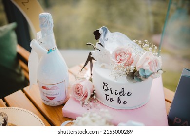 A Closeup Of A Bottle Of Champagne And A Cake Decorated With Pink Roses For ''bride To Be'' Party