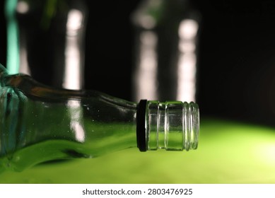 Close-up of a bottle neck, creating depth, reflections, and an artistic still life composition.