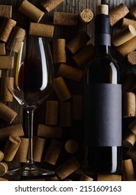 Close-up. A Bottle Of Red Wine And A Glass On The Background Of Wine Corks. There Are No People In The Photo. Restaurant, Hotel, Bar, Festive Atmosphere. Birthday, Date.