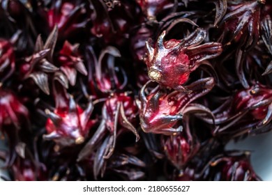 Close-up of a bowl full of hibiscus sabdariffa, or sorrel, a rich red flower used to make sorrel drink in Caribbean countries at Christmas time. Holiday drink, raw flower, cooking ingredient.