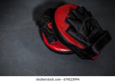 Close-up of boxing gloves and focus mitt in fitness studio - Powered by Shutterstock