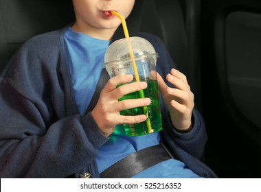 Closeup Of Boy Drinking Green Soda Water In Car