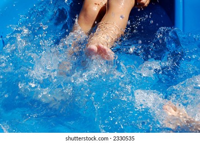 Close-up Of Boy Kicking In Kiddie Pool.