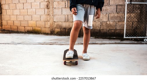 Close-up of a boy practicing standing on a skateboard. on the concrete floor