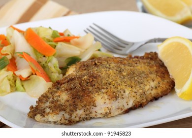 Closeup Of A Breaded Catfish Fillet With A Lemon Slice On A Plate