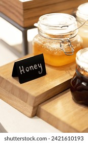 close-up breakfast buffet line serving a variety of jams and honey in hotel with hospitality signs