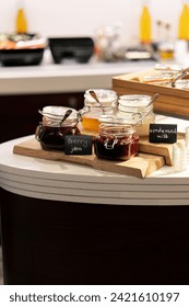 close-up breakfast buffet line serving a variety of jams in hotel with hospitality signs
