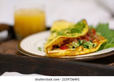 Close-up Of A Breakfast Tray With Scrambled Eggs With Herbs And A Glass Of Orange Juice In A Stylish White Bed No People. Concept: Healthy Breakfast In Bed On A Tray 