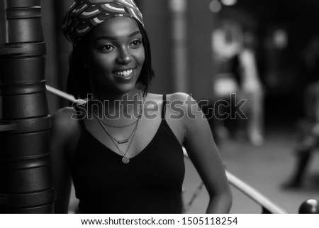 Closeup breast outdoor portrait of young beautiful african woman in black shirt. Trendy lifestyle girl looking at you.