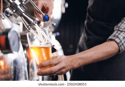 Closeup brewer pours fresh beer from steel tanker at production brewery. - Powered by Shutterstock