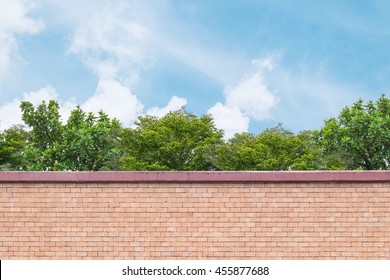 Closeup brick pattern at the brown brick wall of fence with green tree and blue sky with cloud textured background - Powered by Shutterstock