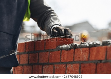 Close-up of Bricklayer laying red bricks on building site