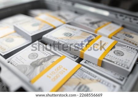 Close-up of briefcase full of stacks of dollar bills, pile of cash. Suitcase with money. Concept of business success, crimes and bribes