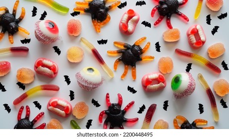 Close-up bright jelly candies,spiders,eyes,jaws,worms and bats,on white background,top view,flat lay,copy space.Decor concept for Halloween party,holiday treat,junk food.Pattern - Powered by Shutterstock