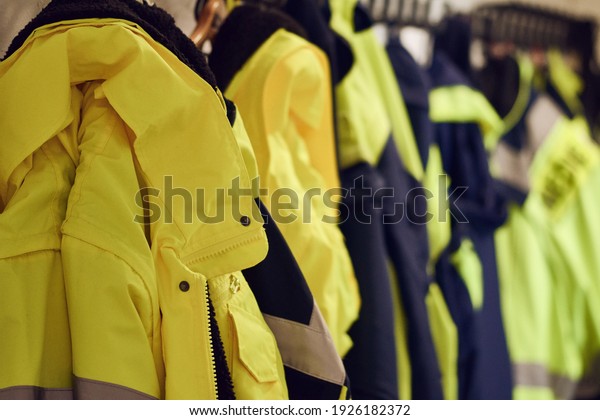 Close-up of bright\
yellow emergency response uniforms arranged in locker room of\
emergency medical\
service.