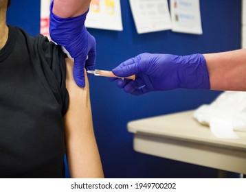 Closeup Of British Asian Woman Getting Injection In Arm, Flu Jab,  Influenza Or Covid 19 Vaccine, UK