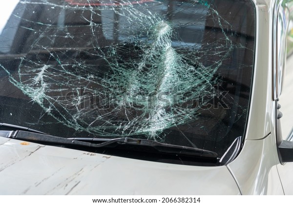 Closeup of\
broken car front shattered glass windscreen of driver side, car\
accident. Broken Windshield car by\
thief.