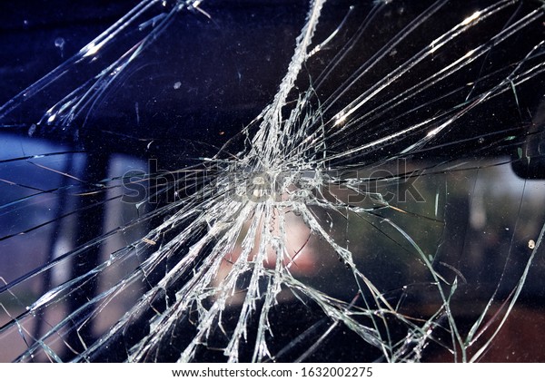 Close-up broken car windshield. Tint blue.Clear\
broken glass have blue sky are background. image for\
texture,background,abstract\
concept