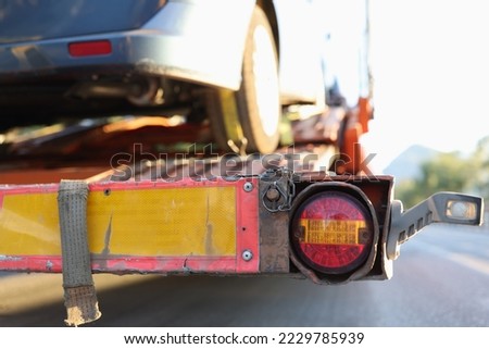 Close-up of broken or damaged car on tow truck. Vehicle evacuation services concept