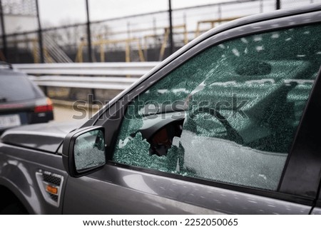 Close-up of a broken driver's window of a car smashed by a thief. Damaged glass from car theft.