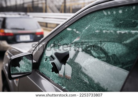 Close-up of a broken driver's window of a car smashed by a thief. Damaged glass from car theft.
