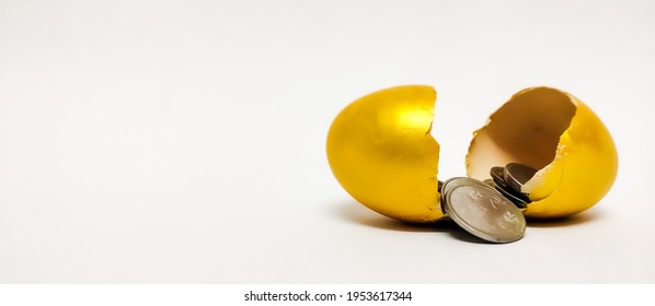 Closeup Of Broken Golden Eggs With Coins Isolated In A White Background With A Selective Focus On Egg Symbolizing The Concept Of Retirement, Money, Savings, Investment, Finance, Banking, Mutual Fund.