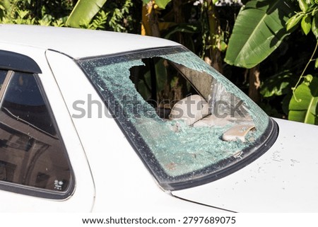 A close-up of a broken windshield on an old, beat-up car