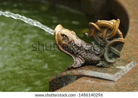 Closeup of a bronze fish statue, traditional fountain decoration