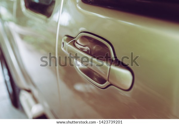 Closeup\
of brown gold car door handle film picture\
style.