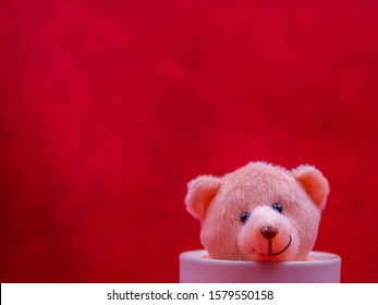 Closeup Brown Smile Teddy Bear Doll In White Coffee Cup On Vivid, Vibrant Gradient Red Copy Space Background For Happiness,  Cheerful Emotion, Kid, Encouragement, Strong, Positive Thinking Concepts.