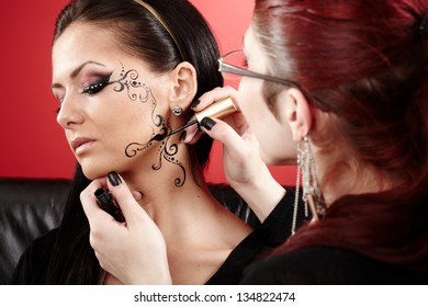 Closeup Of A Brunette Having Applied Face Tattoo By Makeup Artist