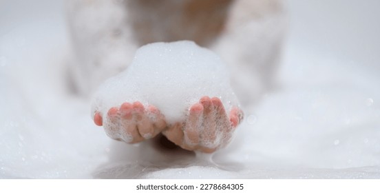 Close-up bubble foam on boy hands surrounded by soap suds when taking a bath in bathtub. Funny, healthcare lifestyle and hygiene concept - Powered by Shutterstock