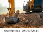 Closeup bucket of backhoe digging the soil at construction site. Crawler excavator digging on demolition site. Excavating machine. Earth moving equipment. Excavation vehicle. Construction business.