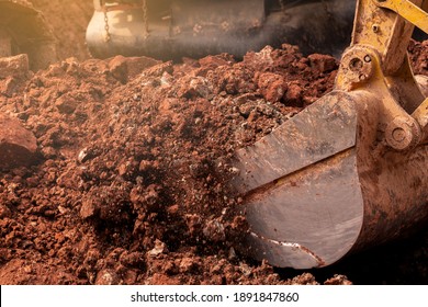 Closeup Bucket Of Backhoe Digging The Soil At Construction Site. Crawler Excavator Digging On Demolition Site. Excavating Machine. Earth Moving Equipment. Excavation Vehicle. Construction Business.