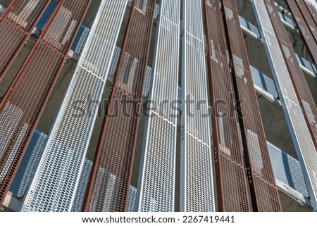 Close-up of a building exterior with white and red perforated metal wall at Austin, Texas. Low angle view of building with open air structure.