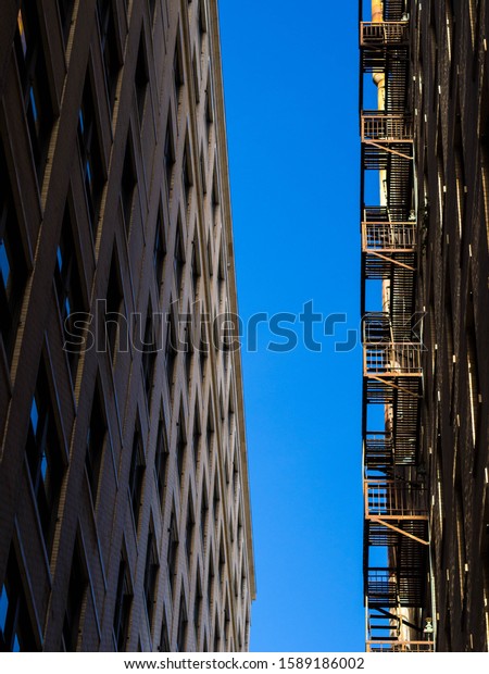 Close-up of a building with fire\
stairs. Clear sky. California. United States of\
America.