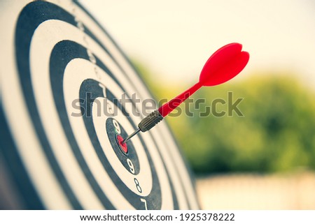 Close-up the bullseye or bulls eye target or dart board has dart arrow throw hitting the center of a shooting for business targeting and aim to winning goals concepts
