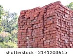 closeup the bunch red bricks keep the row out side over out of focus green sky background.