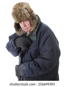 Close-up of a bundled senior man, grumpy as he leans on the handle of he snow shovel.  On a white background.