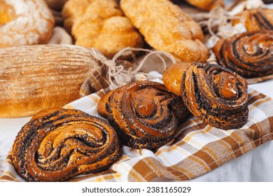 Closeup Buns with poppy seeds. Different types of artisan craft bread in bakery store shelves. - Powered by Shutterstock