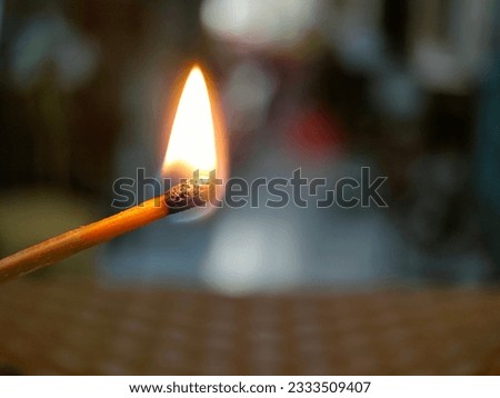 Close-up of burning matchstick, wooden matchstick burning on black background