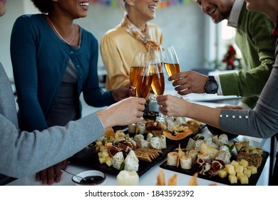 Close-up of business colleagues having a party and toasting with Champagne in the office. - Powered by Shutterstock