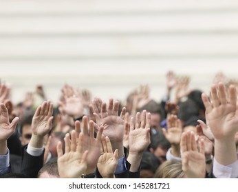 Closeup of business crowd raising hands - Shutterstock ID 145281721
