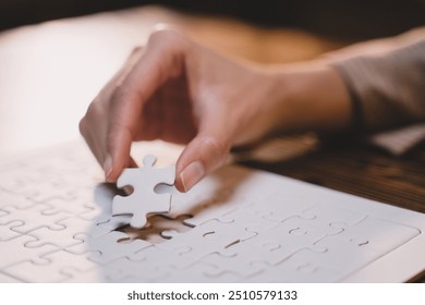 Close-up of business hands connecting jigsaw puzzle, success and goal achievement, the last jigsaw is the link of all the pieces. strategic planning or a solution for the management. - Powered by Shutterstock