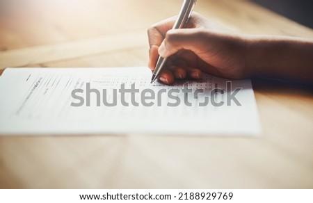 Closeup of business hands of a person filling out paperwork. Hand of an individual writing test, information or survey on paper to complete application or contract form on the desk at work.